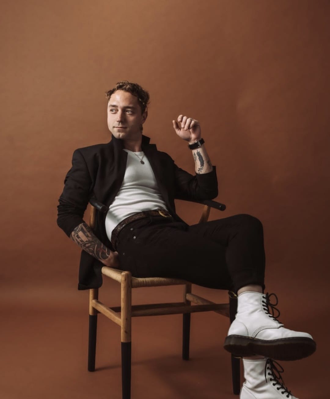Man sitting on a chair against a brown background