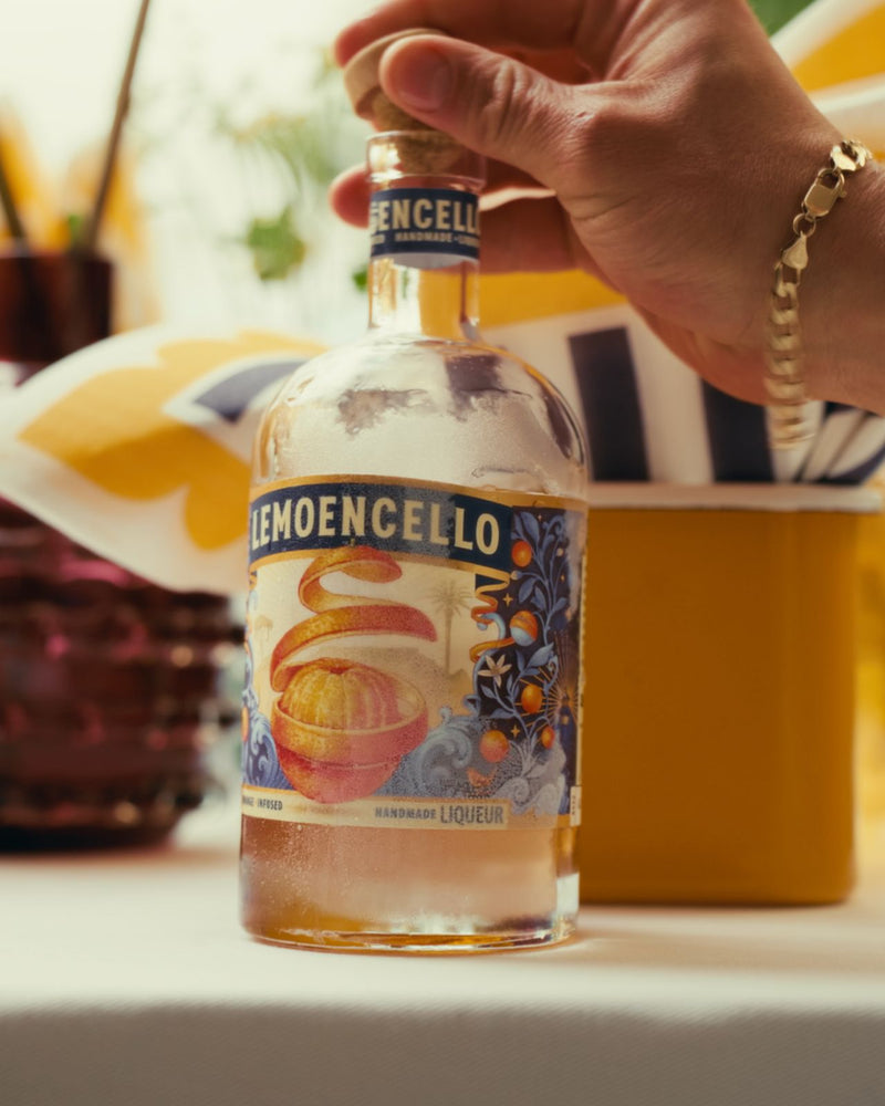 Bottle of Lemoencello liqueur held by a hand with a blurred background