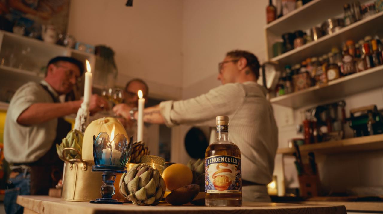 Kitchen setting with bottles, candles, and a person behind the bar.