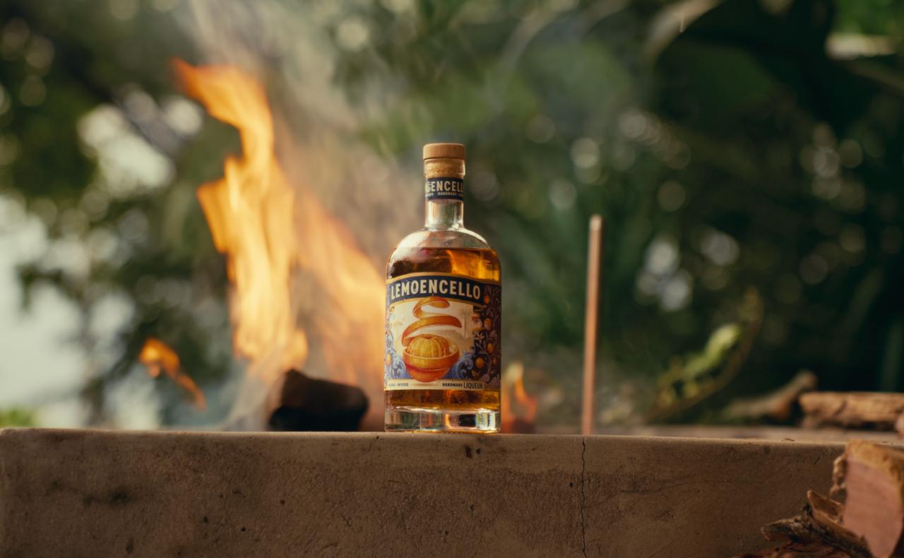 Bottle of Lemoencello brand liquor on a stone surface with a blurred fire background